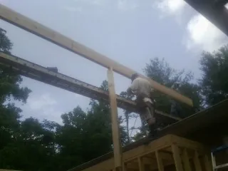Carpenter setting a ridge beam over a new addition frame — Ice Dam Removal by Roofing Brothers in Twain