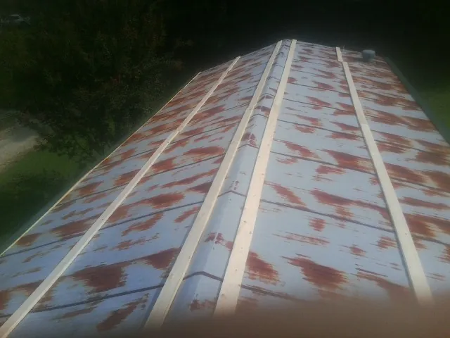 Rusted metal roof panels with new wood purlins before replacement — Storm Damage Roof Repair in Twain by Roofing Brothers