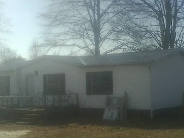New metal roof on a white painted brick home on a foggy morning in Twain