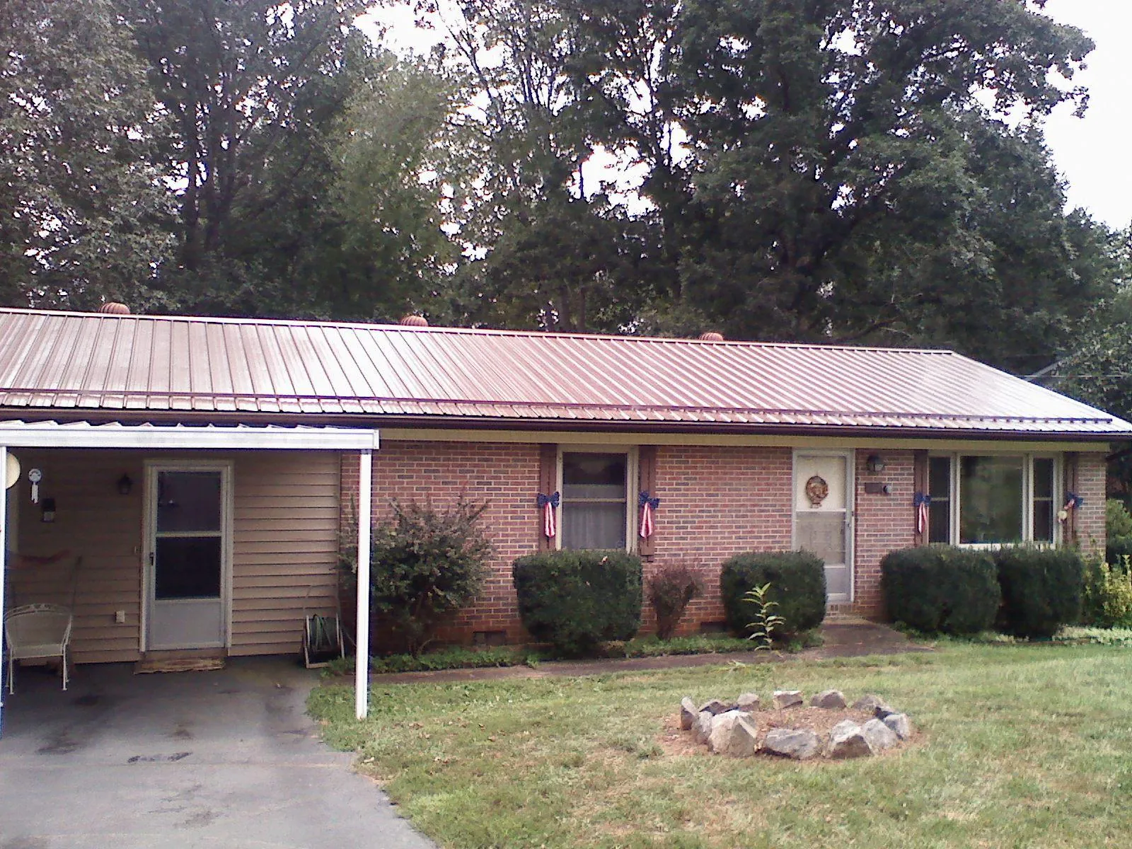Bronze metal roof and carport on a brick ranch home — Roof Repair work by our crew in Twain